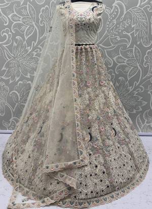 For A Fancy Designer Look,Grab These Lehenga Choli With Dupatta in Fine Colored.These Lehenga And Choli Are Net And Dupatta Are Fabricated On Net Pair.Its Beautified With  Peacock Pattern Crafted In Dori,Thread Embroidery With Zircon Diamond Work. 
