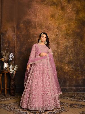 Flaunt Your Rich And Elegant Taste Wearing This Heavy designer Floor Length Suit In All Over Levender Color. Its Top And Dupatta Are Net In Heavy Embroidry Based Paired With Santoon Bottom.