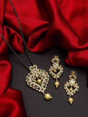 Give An Enhanced Look To Your Personality By Pairing Up This Beautiful Mangal Sutra Set With Your Ethnic Attire. This Pretty Set Is In Gold Color Beautified With American Diamond. Buy Now.