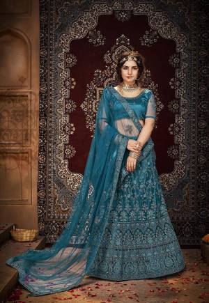 Garb This Heavy Designer Lehenga Choli In All Turquoise Blue Color. This Heavy Embroidered Work Lehenga Choli Is Net Based Paired With Net Fabricated Dupatta, It Is Beautified With Lovely Detailed Heavy Embroidery And Diamond Work Giving An Attractive Look.