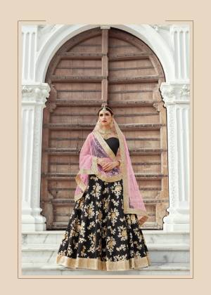 This grand and opulent lehenga set is designed in eye-catching and royal shades of gold and black. It features zari embroidery in flower and leaf motifs all over. The sweetheart neckline blouse giving stunning look to the outfit. It is paired up tith light pink shade dupatta in soft net base.