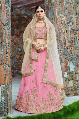 Featuring a baby pink blouse in art silk with pearl golden embroidery and it comes along with baby pink lehenga in art silk. It is paired with beige embroidered dupatta in Net.