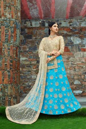 Featuring a Turquoise blue flared lehenga skirt crafted in art silk enhanced with embellished detailing at the bottom. It is paired with a beige blouse in art silk decorated with embroidered motifs. It comes along with a beige dupatta with heavy border.