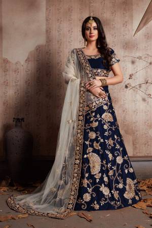 Blue velvet lehenga with zari embroidery highlighted with topaz crystals paired with a champagne Off-white dupatta, with a machine embroidered border.