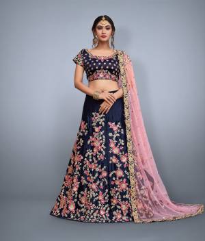 This set features a navy blue velvet blouse with golden sequin and floral embroidery on the front and back. It is paired with blue flared velvet lehenga skirt machine embroidered with gold floral sequin and pink thread work all over the ghera. The lehenga set comes along with peach soft net dupatta ornated with over butti and rich embroidered border on all four sides.