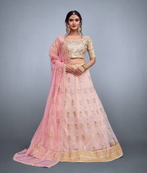 This set features a beige blouse in banglori silk base fully embroidered with mirror, sequins and dori work. It comes along with a baby pink lehenga skirt in soft net with embroidery on ghera and butti flower work scattered all over with zari and mirror work and has an baby pink dupatta in soft net with embroidered flower motifs all over dupatta and floral cutwork lace.