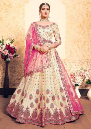 Flaunt Your Rich And Elegant Taste Wearing This Heavy Designer Lehenga Choli In Cream Color Paired With Contrasting Pink Colored Dupatta. This Lehenga Choli Is Fabricated On Satin Paired With Net Fabricated Dupatta. It Has Pretty Resham Embroidery With Stone Work. Buy Now.