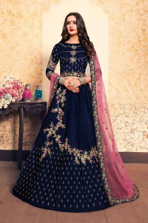 Enhance Yout Personality Wearing This Designer Lehenga Choli In Navy Blue Color Paired With Contrasting Pink Colored Dupatta. This Pretty Lehenga Choli Is Fabricated On Satin Paired With Net Fabricated Dupatta. 