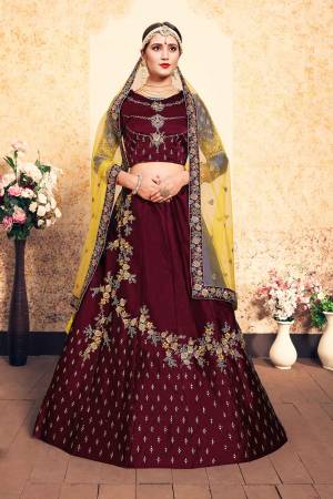 Enhance Yout Personality Wearing This Designer Lehenga Choli In Maroon Color Paired With Contrasting Yellow Colored Dupatta. This Pretty Lehenga Choli Is Fabricated On Satin Paired With Net Fabricated Dupatta. 