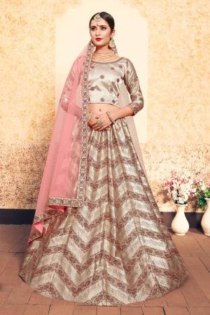 New And Unique Patterned Designer Lehenga Choli Is Here In Light Beige Color Paired With Contrasting Baby Pink Colored Dupatta. Its Blouse And Lehenga Are Fabricated On Satin Paired With Net Fabricated dupatta. All Its Fabrics Are Light Weight And Easy To Carry All Day Long. 