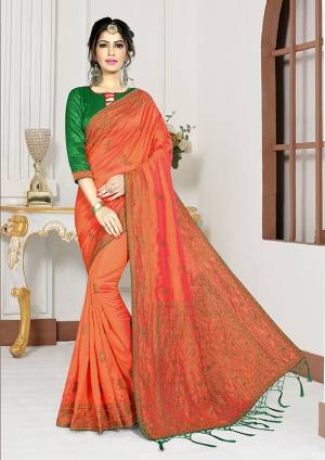 Celebrate This Festive Season Wearing This Designer Saree In Orange Color Paired With Contrasting Green Colored Blouse. This Saree And Blouse Are Silk Based Beautified With Heavy Resham Work. Buy It Now.