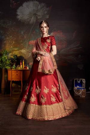 Get Ready For The Upcoming Wedding Season With This Designer Heavy Lehenga Choli In Red color Paired With Peach Colored Dupatta. Its Blouse And Lehenga Are Fabricated On Satin Paired With Net Fabricated Dupatta. It Has Pretty Attractive Embroidery All Over It. 