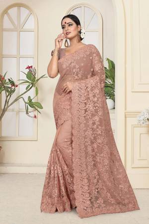 Get Ready For The Upcoming Wedding Season With This Heavy Designer Saree In Dusty Peach Color Which Is Most Trending Color OF The Season. This Saree And Blouse Are Fabricated On Net Beautified With Heavy Tone To Tone Resham and Ceramic Stone Work