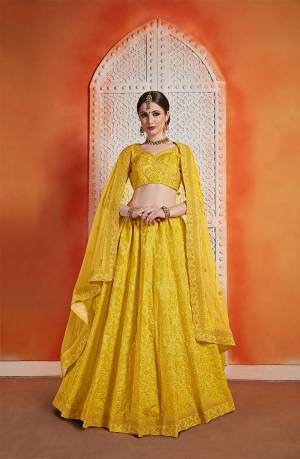 This Wedding Season Be The Most Attractive And Elegant Diva Wearing This Heavy Embroidred Designer Lehenga Choli In All Over Musturd Yellow Color. Its Blouse And Lehenga Are Fabricated On Art Silk Paired With Pretty Net Fabricated Dupatta. 