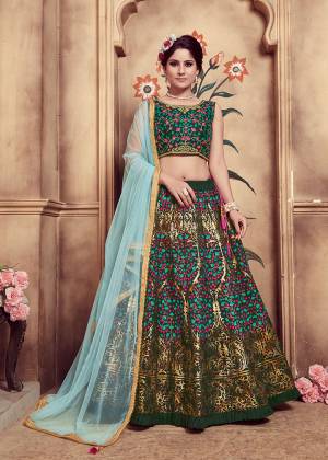 Catch All The Limelight At The Next Wedding You Attend Wearing This Heavy Designer Lehenga Choli In Dark Green Color Paired With Contrasting Aqua Blue Colored Dupatta. Its Blouse And Lehenga Are Fabricated On Art Silk Paired With Net Fabricated Dupatta. 