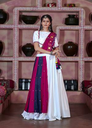 This Navratri, Adorn The Proper Traditional Look Wearing This Designer Lehenga Choli In White And Magenta Pink Color. This Pretty Lehenga Choli Is Cotton Based Beautified With Multi Colored Thread Embroidery And Mirror Work. 