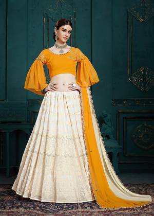 Celebrate This Festive And Wedding Season With Beauty And Comfort Wearing This Lovely Designer Piece In Musturd Yellow Colored Blouse Paired With Off-White Colored Lehenga And Dupatta. It Is Beautified With Embroidery And Attractive Mirror Work. 