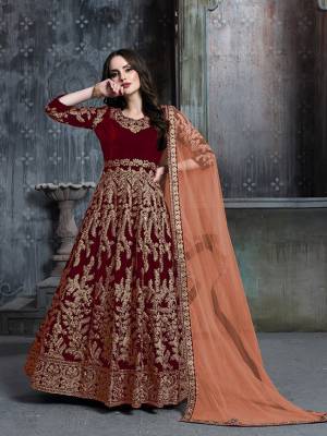 Get Ready For The Upcoming Wedding And Festive Season Wearing This Heavy Designer Floor Length Suit  In Red Color Paired With Light Orange Colored Dupatta. Its Heavy Embroidered Top Is Fabricated on Velvet Paired With Santoon Bottom And Net Fabricated Dupatta. 