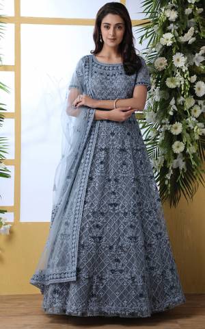 Look Pretty In This Designer Floor Length Gown In Grey Color Paired With Peach Colored Dupatta. Its Heavy Embroidered Top Is Fabricated On Net Paired With Net fabricated Dupatta. Buy This Semi-Stitched Designer Gown Now.