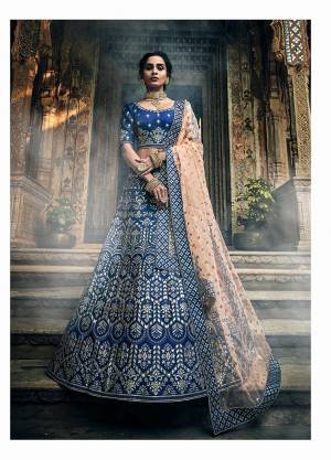 Here Is A Lovely Heavy Designer Lehenga Choli In Blue Color Paired With Contrasting Peach Colored Dupatta. This Heavy Embroidered Lehenga Choli Is Fabricated On Art Silk Paired With Net Fabricated Dupatta. Buy This Lehenga Choli Now.