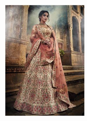 Get Ready For The Upcoming Wedding Season With This Very Beautiful Heavy Designer Lehenga Choli With Detailed Embroidery In Cream Color Paired With Peach Colored Dupatta. This Lehenga Choli Is Fabricated On Art Silk Paired With Net Fabricated Dupatta. Buy Now.