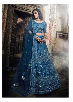 Adorn The Pretty Angelic Look Wearing This Heavy Designer Lehenga Choli In All Over Cobalt Blue Color. This Lehenga Choli Is Art Silk Based Paired With Net Fabricated Dupatta. It Is Beautified With Pretty Tone To Tone Embroidery Giving A Subtle Look To Your Personality. 