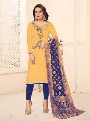 For Your Semi-Casual Wear, Grab This Designer Embroidered Dress Material In Yellow Colored Top Paired With Contrasting Navy Blue Colored Bottom And Dupatta. This Dress Material Is Cotton Based Paired With Banarasi Silk Fabricated Dupatta. 