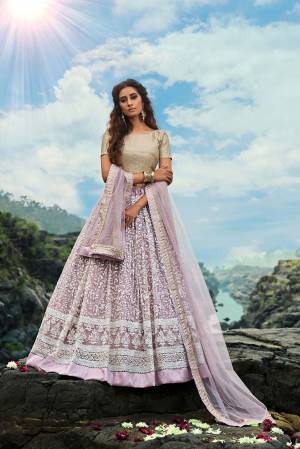 Add This Very Pretty And Girly Designer Lehenga Choli To Your Wardrobe In Cream Colored Blouse Paired With Lilac Colored Bottom And Dupatta. This Pretty Piece Is Fabricated On Net Beautified With Attractive Embroidery Work. 