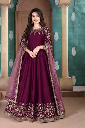 Here Is A Designer Floor Length Suit In Wine Color Paired With Grey Colored Dupatta. Its Pretty Embroidered Top Is Fabricated on Slub Silk Paired With Santoon Bottom and Net Fabricated Dupatta. Buy Now.