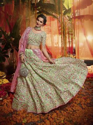 Here Is A Very Beautiful Heavy Embroidered Designer Lehenga Choli In Light Green Color Paired With Contrasting Pink Colored Dupatta. Its Lovely Blouse and Lehenga are Fabricated On Orgenza Paired With  Net Fabricated Dupatta. Its Pretty Color Pallete And Attractive Embroidery Will Earn You Lots Of Compliments From Onlookers. 