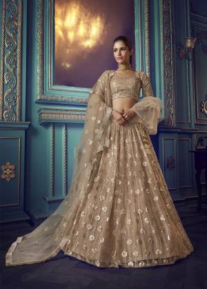 Get Ready For The Upcoming Wedding and Festive Season Wearing This Heavy Designer Lehenga Choli In Beige Color. Its Blouse And Lehenga Are Fabricated On Net Beautified With Heavy Attractive Embroidery. 