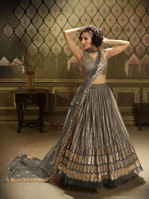 Get Ready For This Wedding Season Wearing This Heavy Designer Lehenga Choli In Grey Color. This Beautiful Heavy Embroidered Lehenga Choli Is Fabricated On Net Beautified With Jari Embroidery And Sequence Work. 